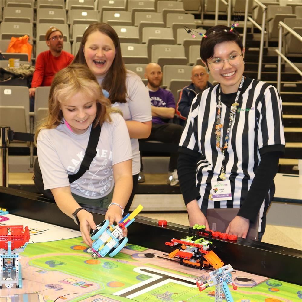  Girls and referee at robotics tournament
